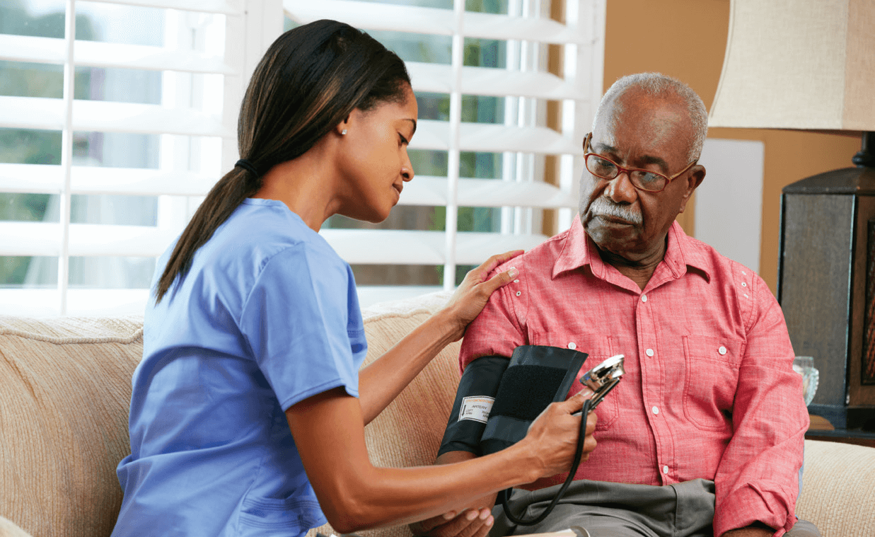 nurse checking blood pressure on an elderly man